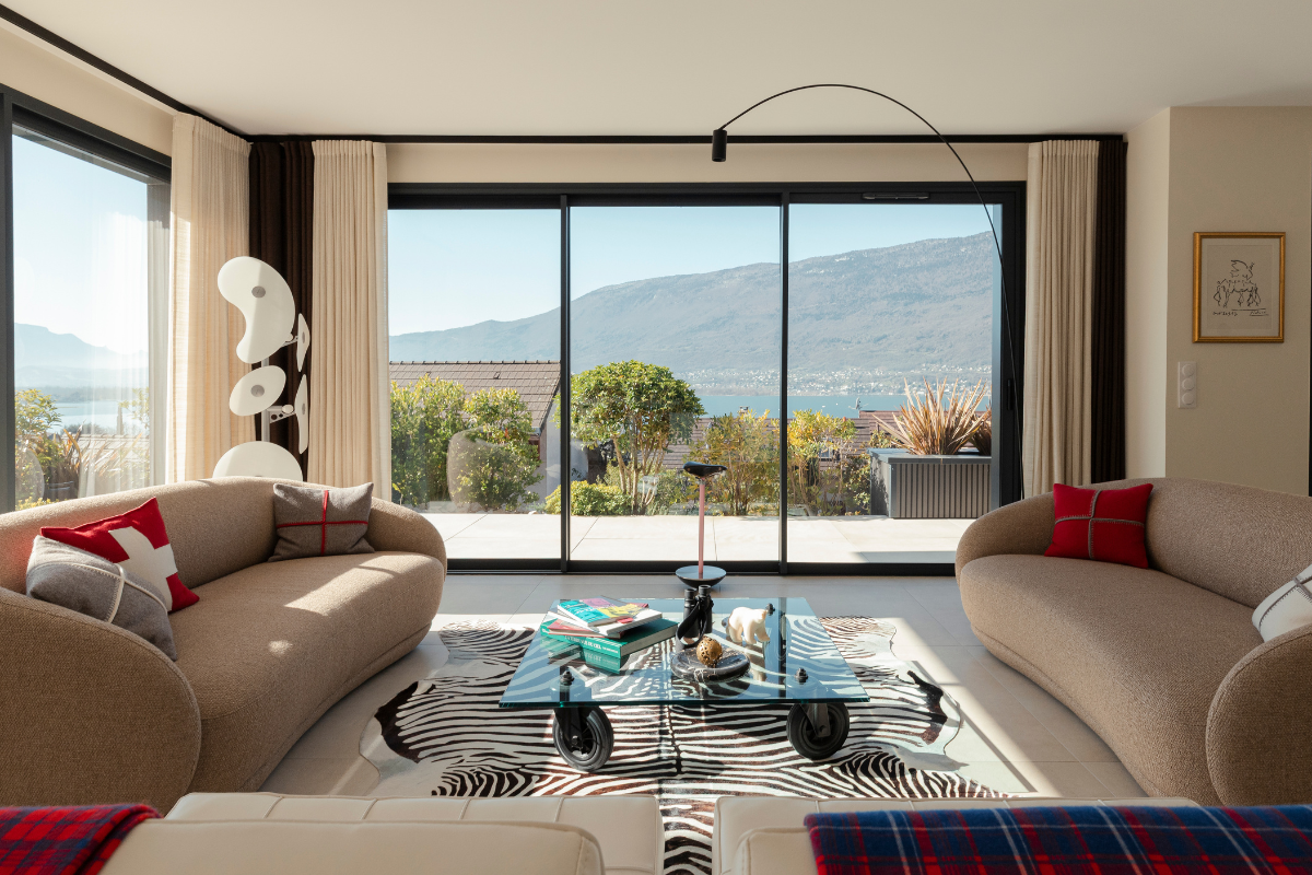 Vue plongeant sur le lac depuis le salon de cette magnifique maison réalisée par Maisons Alpes Savoie, à Tresserves en Savoie.