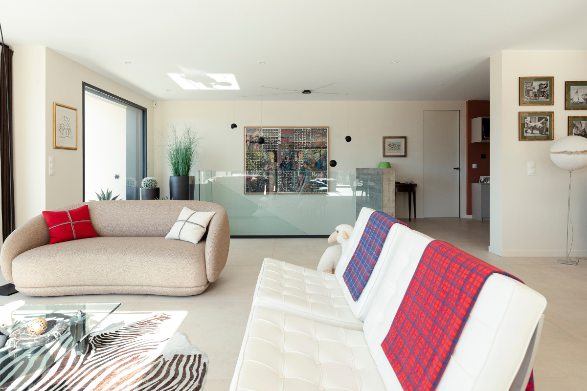 salon moderne avec vue sur le lac dans une maison individuelle réalisée par Maisons Alpes Savoie à Tresserves, en Savoie.