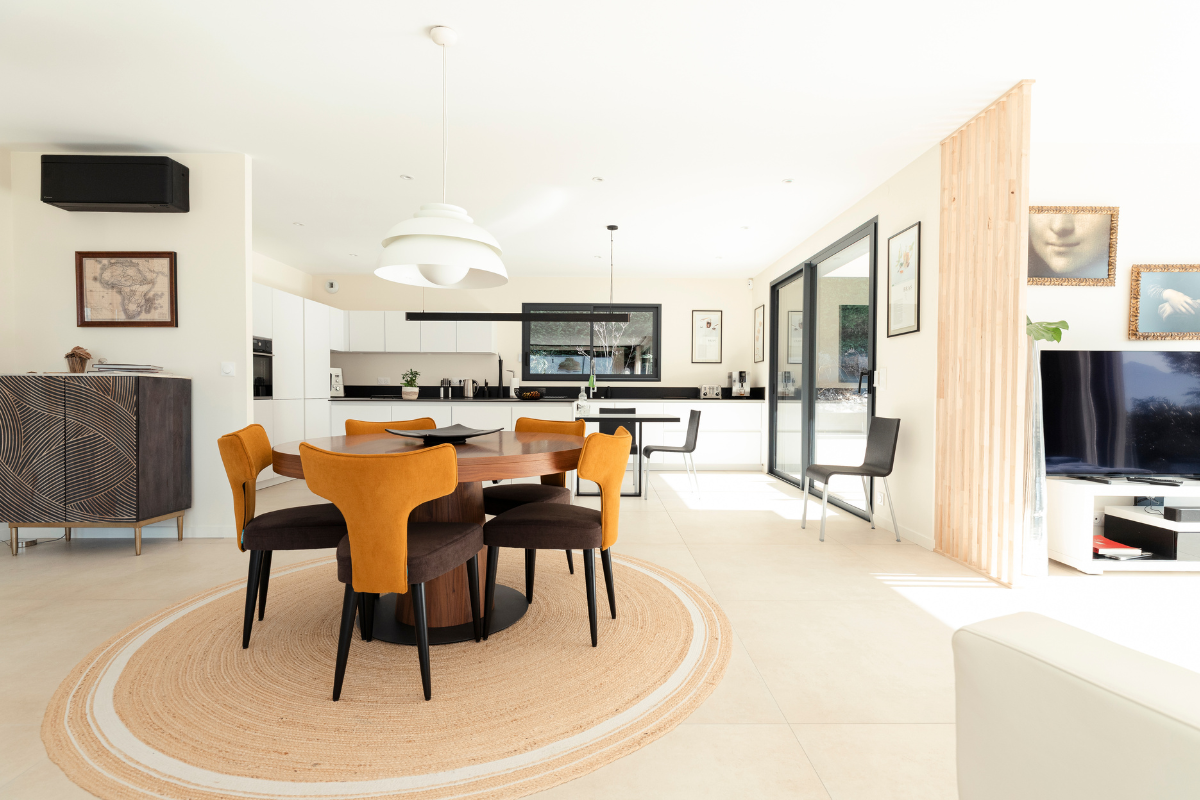 Salle à manger prise depuis le salon dans une maison individuelle réalisée par Maisons Alpes Savoie en Savoie, à Tresserves.